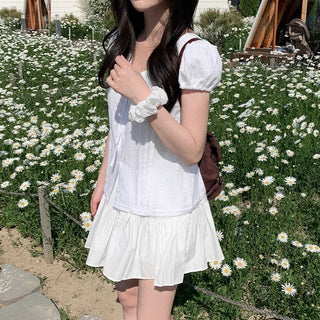 Short-sleeved summer outfit featuring a ruffled collar, puff sleeves, and shirred top.