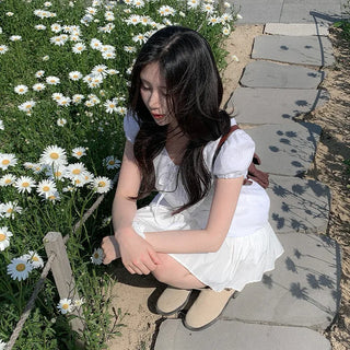 Short-sleeved summer outfit featuring a ruffled collar, puff sleeves, and shirred top.