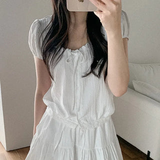 Short-sleeved top with ribbon collar, puff sleeves, and shirring.