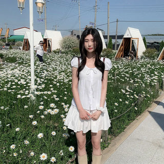 Short-sleeved summer outfit featuring a ruffled collar, puff sleeves, and shirred top.