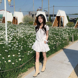 Short-sleeved top with ribbon collar, puff sleeves, and shirring.