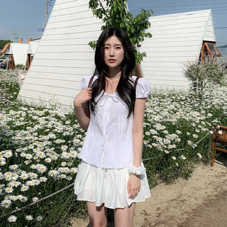 Short-sleeved summer outfit featuring a ruffled collar, puff sleeves, and shirred top.