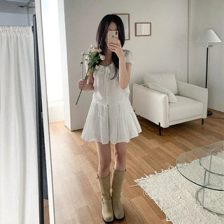 Short-sleeved top with ribbon collar, puff sleeves, and shirring.