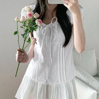 Short-sleeved summer outfit featuring a ruffled collar, puff sleeves, and shirred top.