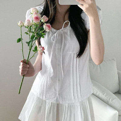 Short-sleeved summer outfit featuring a ruffled collar, puff sleeves, and shirred top.
