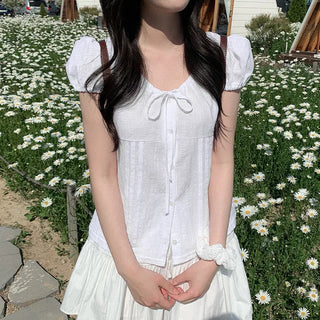 Short-sleeved summer outfit featuring a ruffled collar, puff sleeves, and shirred top.