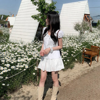 Short-sleeved summer outfit featuring a ruffled collar, puff sleeves, and shirred top.