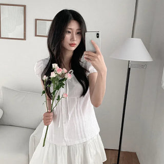 Short-sleeved summer outfit featuring a ruffled collar, puff sleeves, and shirred top.