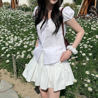 Short-sleeved summer outfit featuring a ruffled collar, puff sleeves, and shirred top.