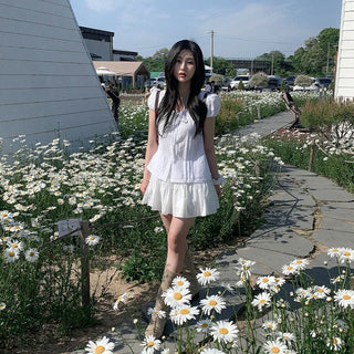 Short-sleeved summer outfit featuring a ruffled collar, puff sleeves, and shirred top.