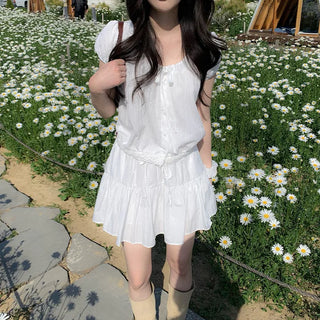 Short-sleeved top with ribbon collar, puff sleeves, and shirring.