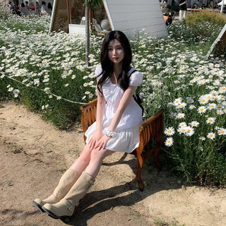 Short-sleeved summer outfit featuring a ruffled collar, puff sleeves, and shirred top.