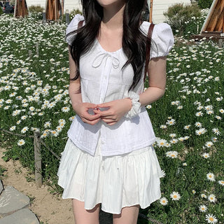 Short-sleeved summer outfit featuring a ruffled collar, puff sleeves, and shirred top.