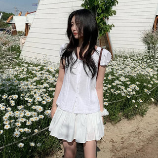 Short-sleeved summer outfit featuring a ruffled collar, puff sleeves, and shirred top.