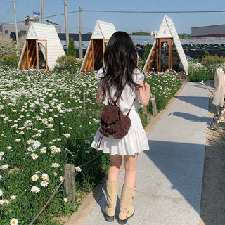 Short-sleeved top with ribbon collar, puff sleeves, and shirring.