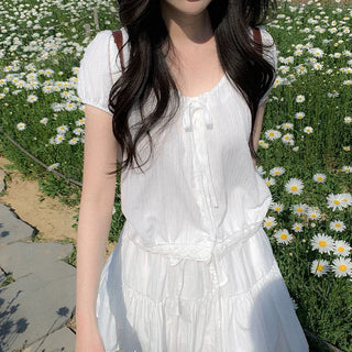 Short-sleeved top with ribbon collar, puff sleeves, and shirring.