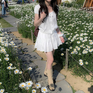 Short-sleeved top with ribbon collar, puff sleeves, and shirring.