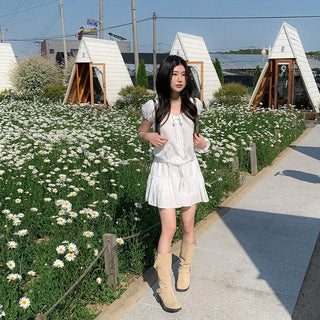 Short-sleeved top with ribbon collar, puff sleeves, and shirring.