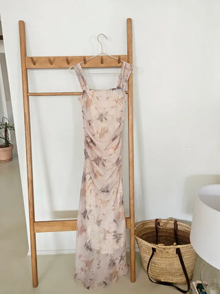 Beige long one-piece dress with a sleeveless shirring slim square neck and straps for a resort vacation look.