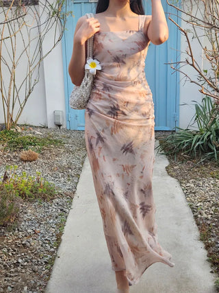 Beige long one-piece dress with a sleeveless shirring slim square neck and straps for a resort vacation look.