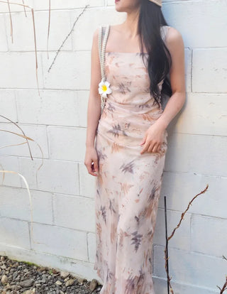 Beige long one-piece dress with a sleeveless shirring slim square neck and straps for a resort vacation look.