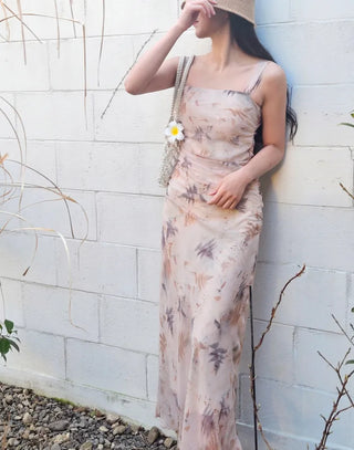Beige long one-piece dress with a sleeveless shirring slim square neck and straps for a resort vacation look.