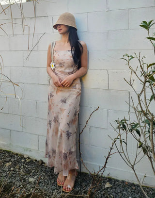 Beige long one-piece dress with a sleeveless shirring slim square neck and straps for a resort vacation look.