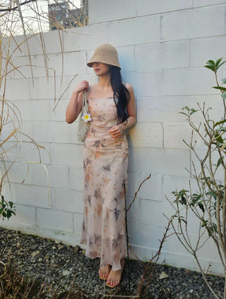 Beige long one-piece dress with a sleeveless shirring slim square neck and straps for a resort vacation look.