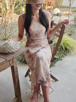 Beige long one-piece dress with a sleeveless shirring slim square neck and straps for a resort vacation look.