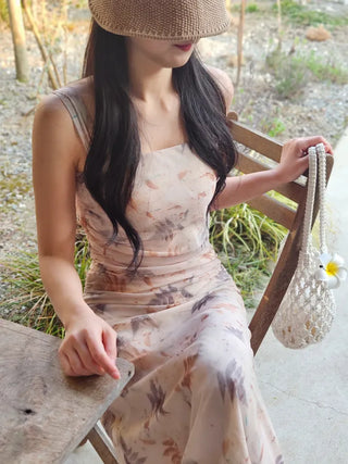 Beige long one-piece dress with a sleeveless shirring slim square neck and straps for a resort vacation look.