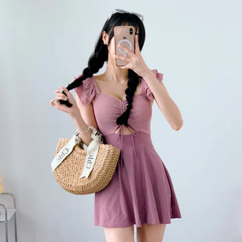 Cute pink one-piece swimsuit with shirring wings and frills including underwear.