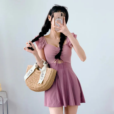 Cute pink one-piece swimsuit with shirring wings and frills including underwear.