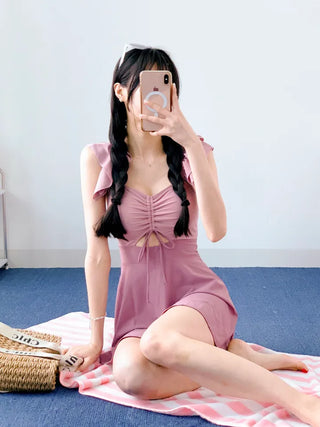 Cute pink one-piece swimsuit with shirring wings and frills including underwear.
