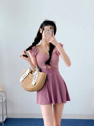 Cute pink one-piece swimsuit with shirring wings and frills including underwear.
