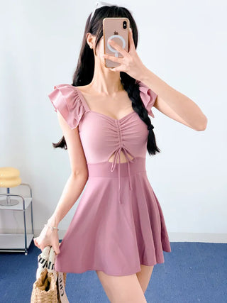 Cute pink one-piece swimsuit with shirring wings and frills including underwear.