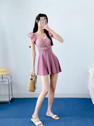 Cute pink one-piece swimsuit with shirring wings and frills including underwear.