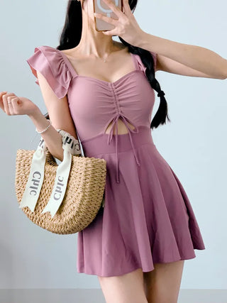 Cute pink one-piece swimsuit with shirring wings and frills including underwear.