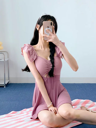 Cute pink one-piece swimsuit with shirring wings and frills including underwear.