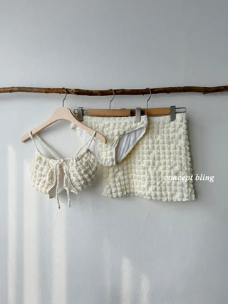 Embossed piece bikini with a vacation check ivory strap and a unique piece skirt.