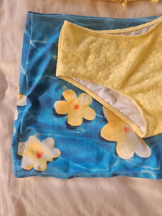 piece swimsuit set including yellow tube top and flower beaded bikini skirt. Beach look.