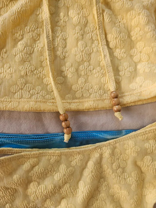 piece swimsuit set including yellow tube top and flower beaded bikini skirt. Beach look.