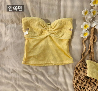 piece swimsuit set including yellow tube top and flower beaded bikini skirt. Beach look.