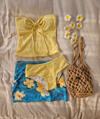 piece swimsuit set including yellow tube top and flower beaded bikini skirt. Beach look.