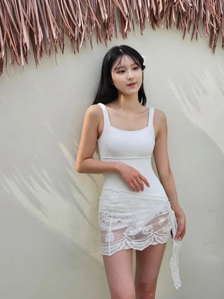 Pure white one-piece swimsuit two-piece set with lace wrap skirt and cover-up and a luxurious vacation pool villa.