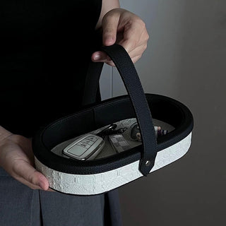 Oval-shaped leather jacquard tray with handlein .