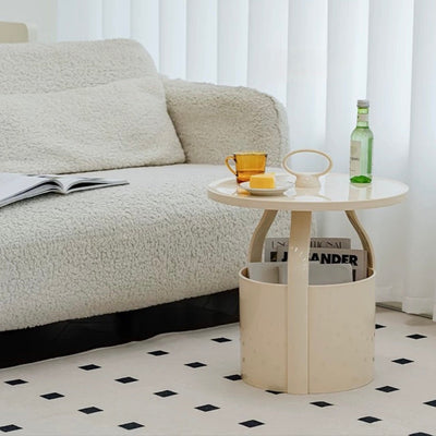 Round storage side table with handlein  includes magazine rack.