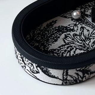 Oval-shaped leather jacquard tray with handlein .