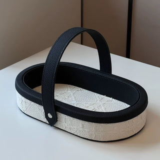 Oval-shaped leather jacquard tray with handlein .