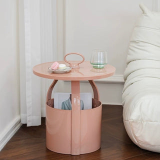 Round storage side table with handlein  includes magazine rack.