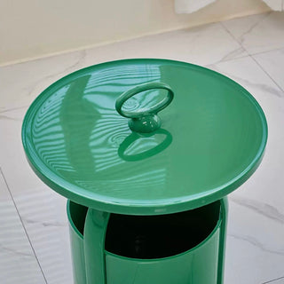 Round storage side table with handlein  includes magazine rack.
